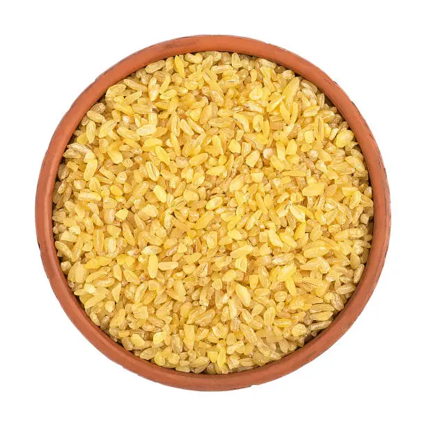 Raw Bulgur in a bowl Isolated on a white background. View from above