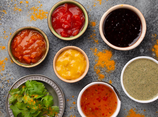 Assorted Indian chutneys Assorted Indian chutneys in small rustic bowls on grey concrete background. Top view of colorful chutney, traditional Indian sauces and dips as a snack or side dish, close-up gravy photos stock pictures, royalty-free photos & images