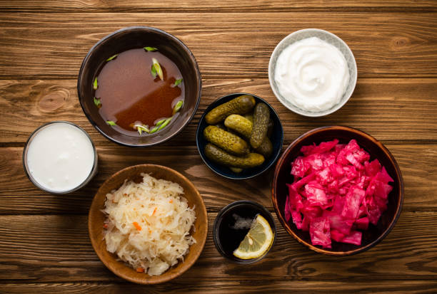 Assorted fermented foods Top view of assorted fermented foods and drinks, sources of probiotics great for healthy gut and digestive system: kimchi, pickles, sauerkraut, miso soup, kombucha, yogurt, kefir, wooden background bifidobacterium stock pictures, royalty-free photos & images
