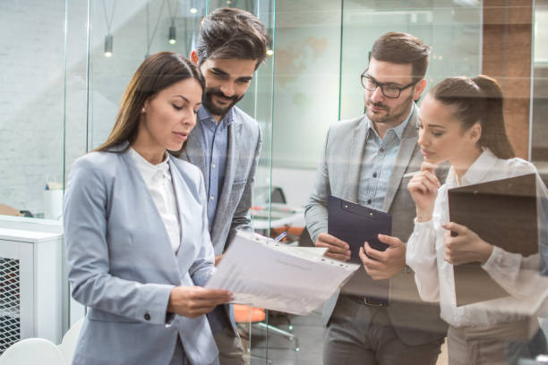 istock Business team discussing business documents, standing in the office lobby 1221799323