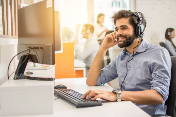 istock Smiling friendly handsome young male call centre operator. 1221799974