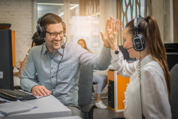 istock Call center operators giving high five to each other, celebrating corporate successful teamwork at office. 1221800225