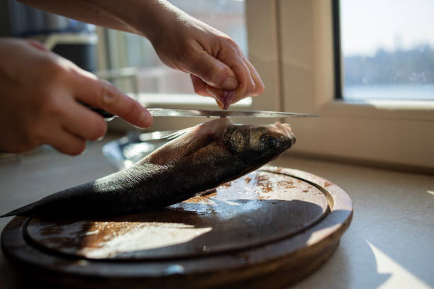Woman preparing sea bass fish