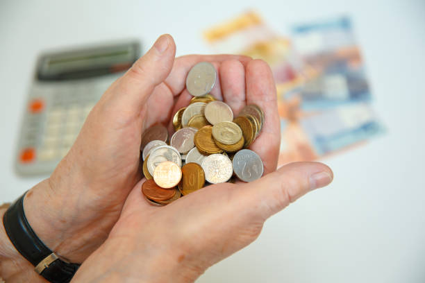 istock An elderly woman holds many different coins in her hands 1221806922