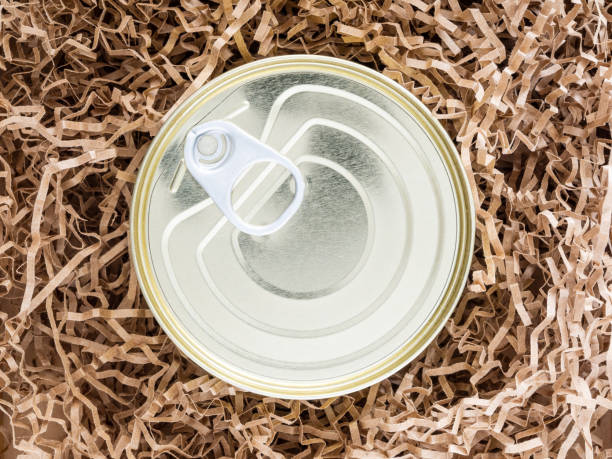 istock Tin can wrapped in paper, shockproof packaging, close-up, mock-up. Concept: a funny gift in quarantine. Careful delivery of food to the quarantine. Donating food items. Food help 1221808084