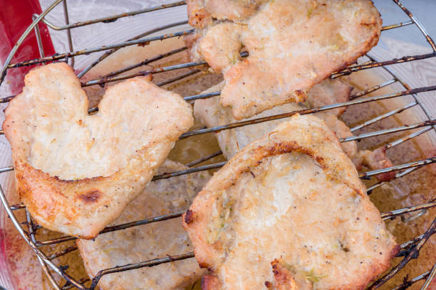 porc dans les aliments de santé au four. rôtir la viande au four. longe de porc cuite au four. rôti de porc entier cuit avec la ficelle de cuisine. côtes de porc cuites au four sur le plateau au four. viande assaisonnée à l’ail frit au four. - barbecue lunch dinner loin photos et images de collection