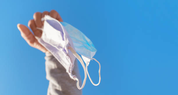 istock Man hand holding mask, protective masks against sun light. 1221809887