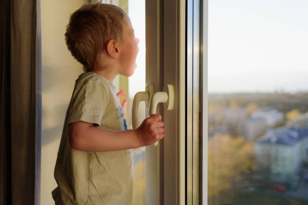 istock Child opening window without parents. Dangerous situation 1221813976