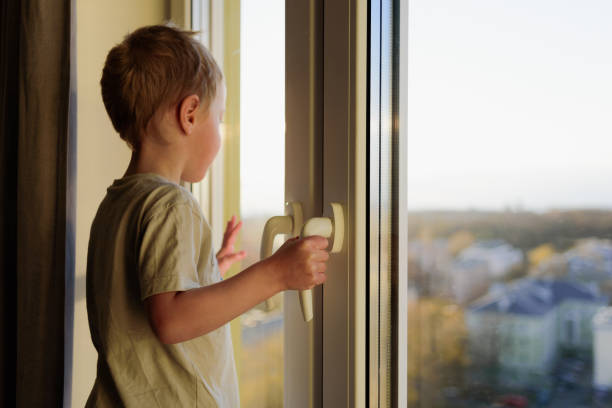 istock Child opening window without parents. Dangerous situation 1221814075