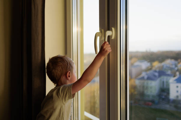 istock Child opening window without parents. Dangerous situation 1221814150