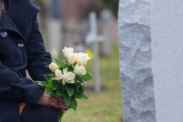 kvinna lämnar blommor vid en grav - blommor grav bildbanksfoton och bilder