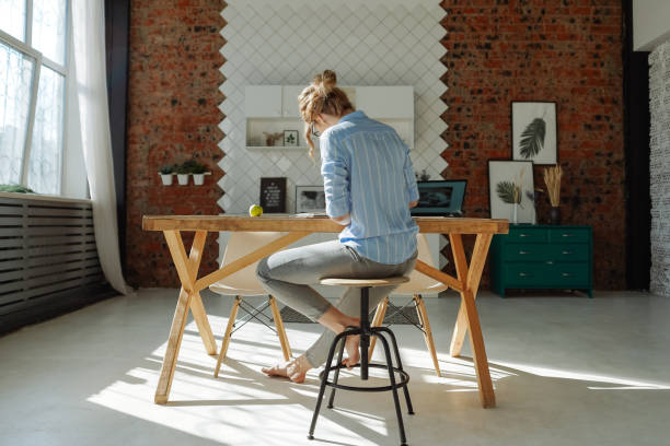 istock Back view of a girl working at home 1221819100