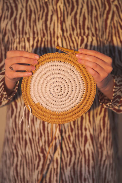 round raffia crochet panno in female hands. - passion women human hand macro imagens e fotografias de stock