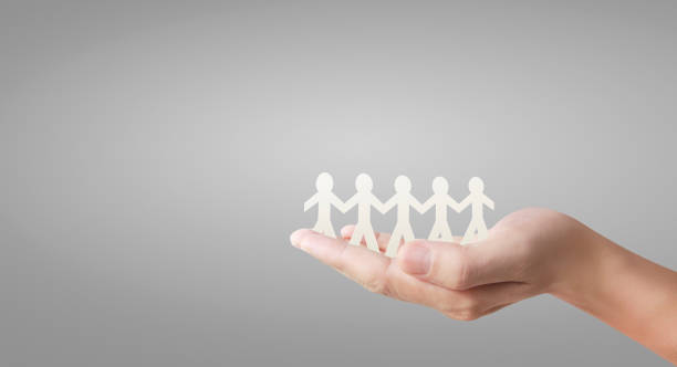 istock Human shape in paper cut with hand by hand or shake hand in hand 1221819496