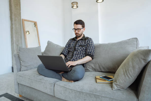istock Man working on a couch with legs crossed 1221819897