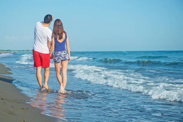 istock Happy young couple having fun at beach on sunny day 1221820569