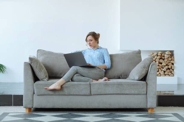 istock Woman using laptop on a couch 1221821240