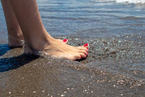human feet sunbathing on the beach