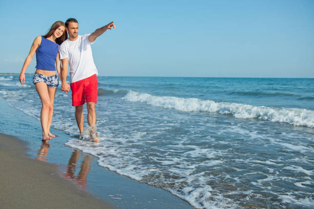 istock Happy young couple having fun at beach on sunny day 1221825867