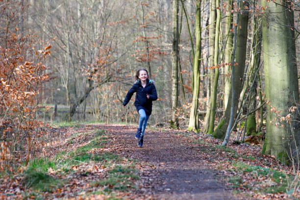 istock A girl is running on a path in the woods 1221826066