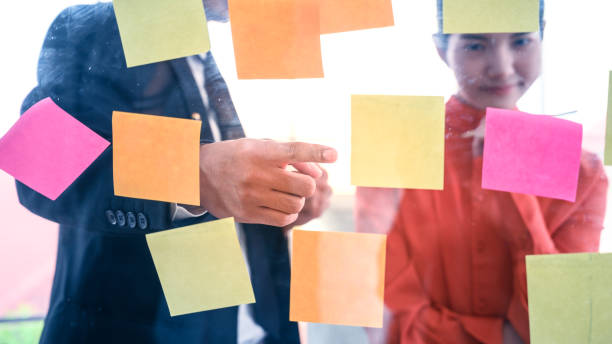 istock Business couple   meeting at office and use post it notes to share idea. 1221826287