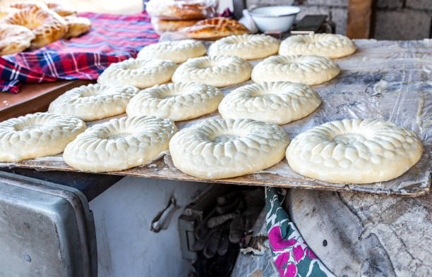Traditional uzbek round flatbreads is preparing to put in the tandyr