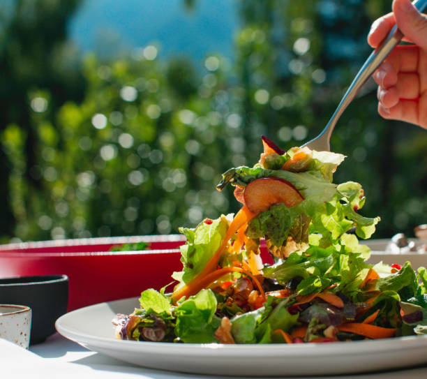 istock Raw leafy green salad being lifted with a fork 1221826909