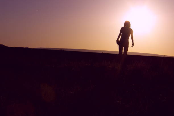 istock Woman silhouette at sunset 1221827859