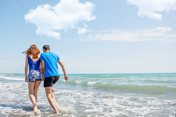 istock Happy young couple having fun at beach on sunny day 1221828599