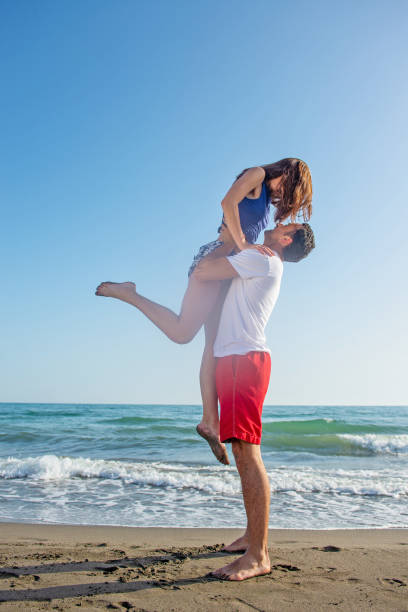 istock Happy young couple having fun at beach on sunny day 1221829583