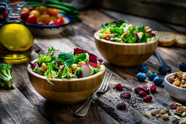 istock Two healthy fresh salad bowls shot on rustic wooden table 1221831825