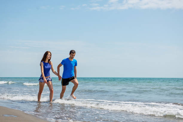 istock Happy young couple having fun at beach on sunny day 1221832238