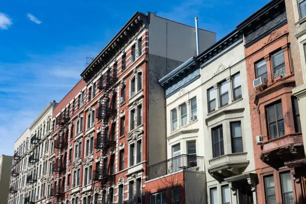 Photo of Row of Colorful Old Buildings with Fire Escapes in Harlem of New York City