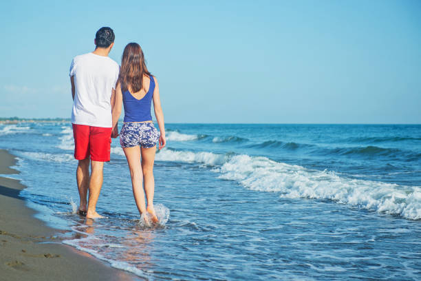 istock Happy young couple having fun at beach on sunny day 1221834385