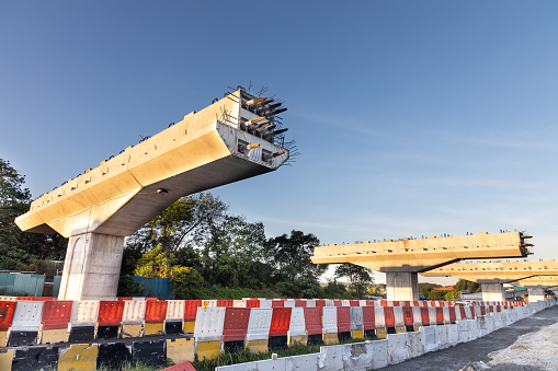 Construction of highway overpass bridge infrastructure in progress with morning sun rays in Malaysia
