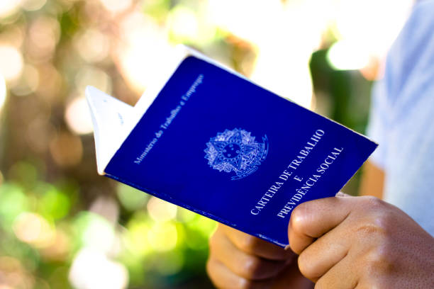 el hombre tiene su documento brasileño de trabajo y seguridad social (carteira de trabalho e previdencia social) - arriba de fotografías e imágenes de stock