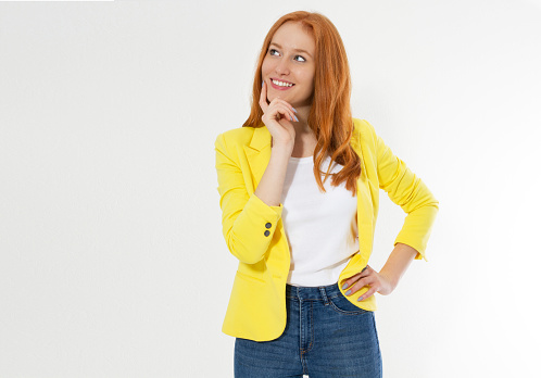 Happy beautiful young red head woman in a stylish yellow jacket copy space. Attractive red hair girl looking away.