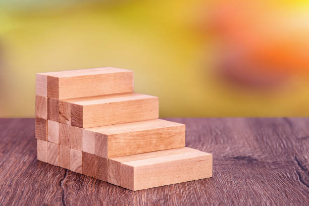 istock Man builds a wooden ladder. Concept: stable development 1221838767