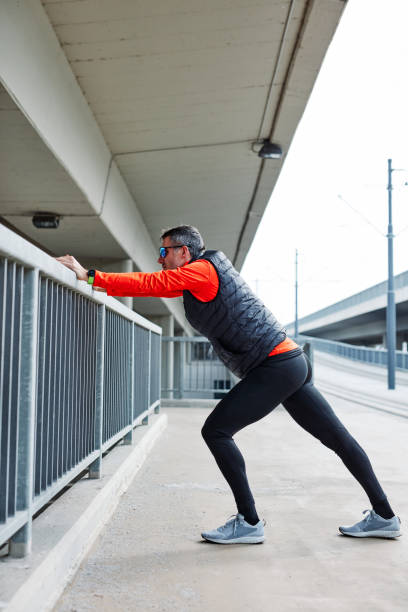 istock Side view of runner stretching his leg and warming up. 1221844359