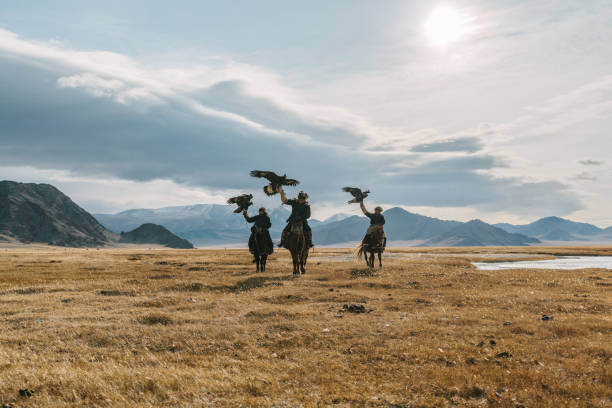 porträt einer gruppe von adlerjägern in der nähe des flusses in der mongolei - gobi desert stock-fotos und bilder