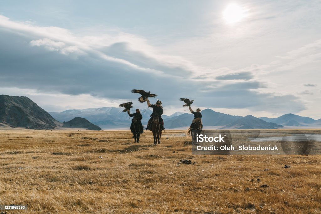 Portrait of group of eagle hunters near the river in Mongolia Portrait of group of eagle hunters in Mongolia  on the background of river Asia Stock Photo