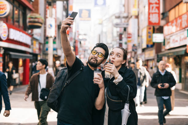 Couple taking a selfie while drinking bubble tea Interracial couple drinking boba and taking a selfie travel destinations 20s adult adventure stock pictures, royalty-free photos & images