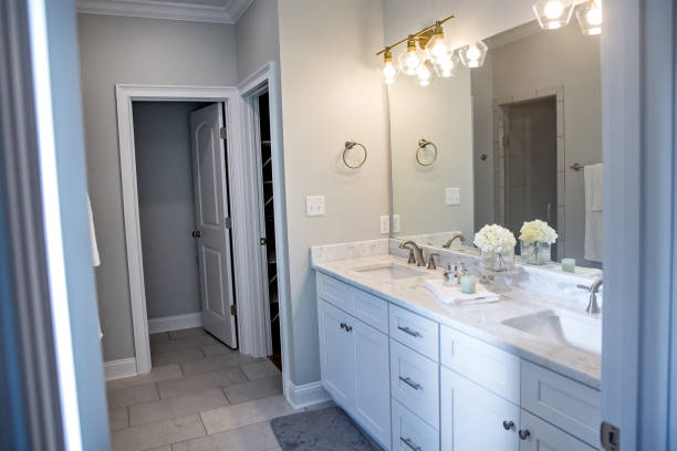 istock All white and gray modern contemporary master bathroom in a small new construction house with tiled floor, a vanity cabinet, double sinks and a mirror 1221847253