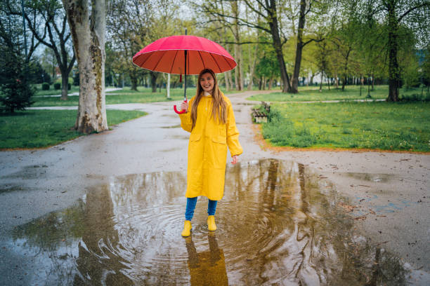 istock Joyful woman walking in rainy weather 1221847421