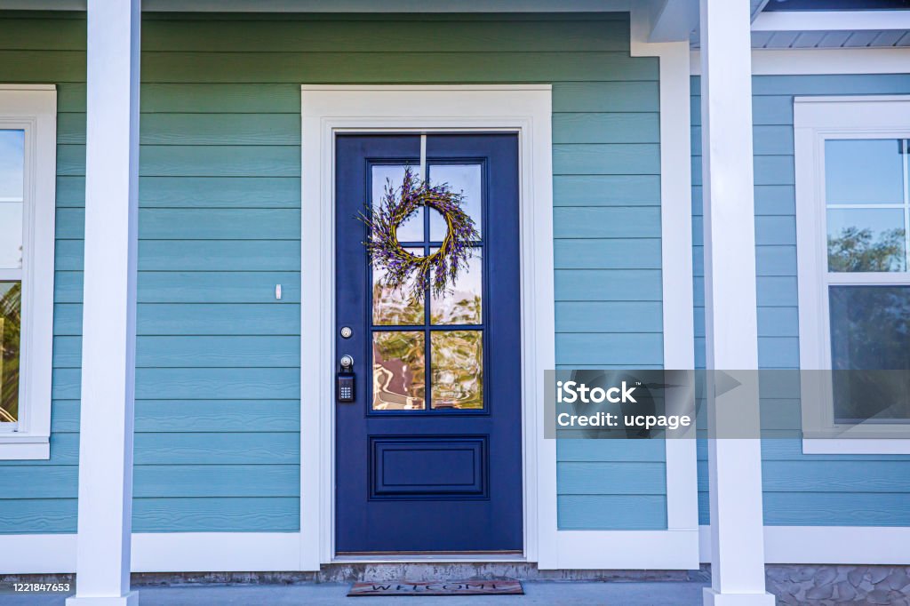 Blue Front Door of a brand new construction house with blue siding, a  ranch style home with a yard Blue front door of a brand new construction house with blue siding, a  ranch style home with a yard Front Door Stock Photo