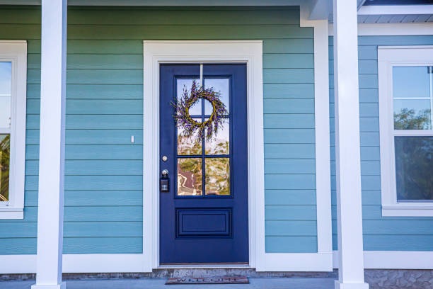 Blue Front Door of a brand new construction house with blue siding, a ranch style home with a yard Blue front door of a brand new construction house with blue siding, a ranch style home with a yard siding building feature photos stock pictures, royalty-free photos & images