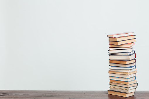 a lot of stacks of books for college on a white background