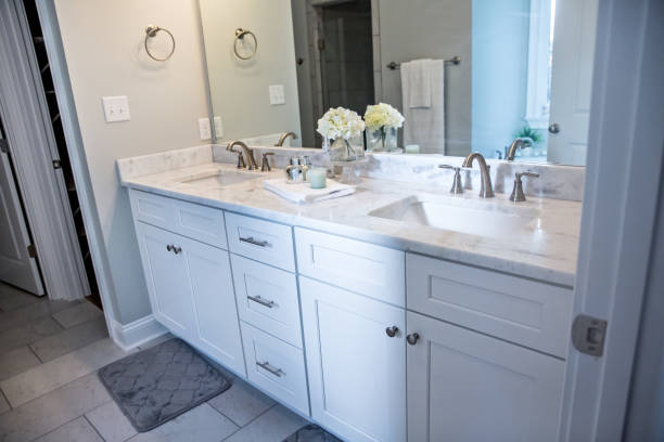 istock All white and gray modern contemporary master bathroom in a small new construction house with tiled floor, a vanity cabinet, double sinks and a mirror 1221848053