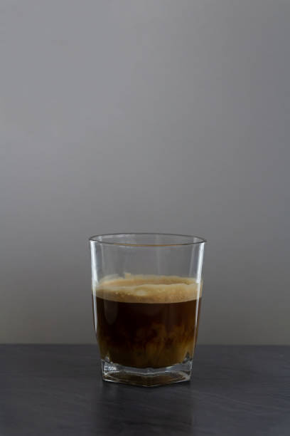 istock Milk mix in coffee in small glass on stone desk. 1221848131