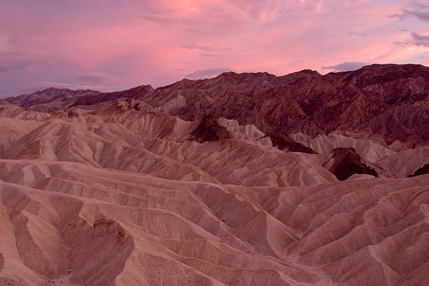 Zabriskie Point at Sunset, highlighted by the pink sky stock photo